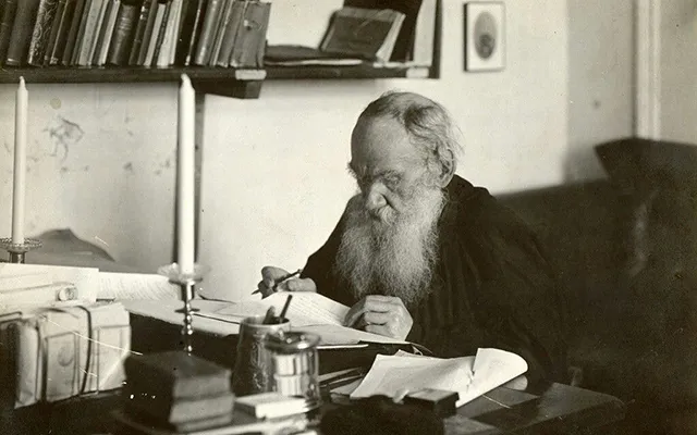 Лев Толстой пишет за столом