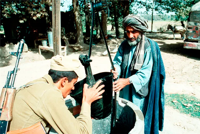 Советский солдат пьет воду из ведра местного жителя, 1986 год